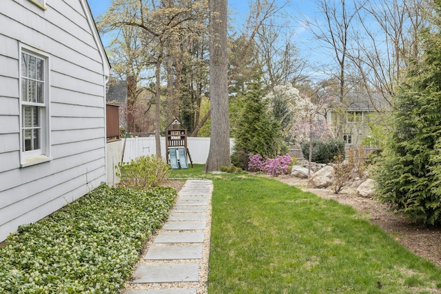 view of yard featuring fence and a playground