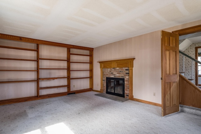 unfurnished living room featuring baseboards, a brick fireplace, and carpet