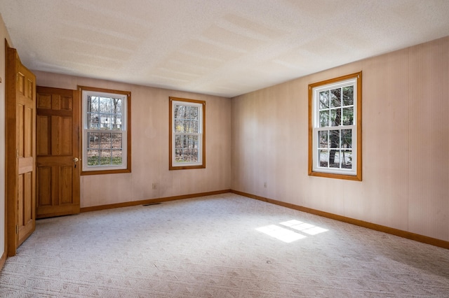 unfurnished room featuring baseboards and light colored carpet