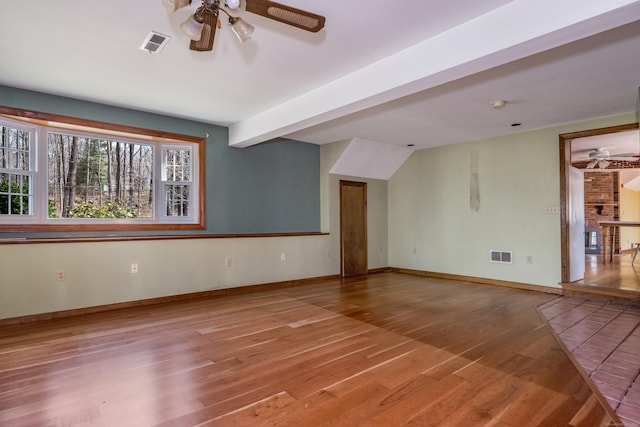 unfurnished living room with wood finished floors, visible vents, and ceiling fan
