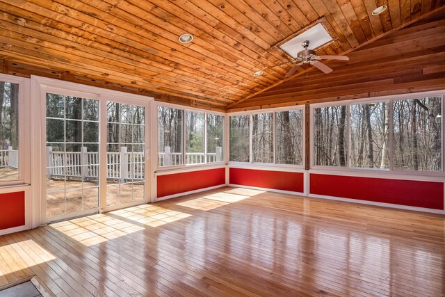unfurnished sunroom featuring a ceiling fan and a skylight