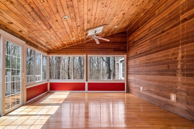 unfurnished sunroom featuring vaulted ceiling, a ceiling fan, hardwood / wood-style floors, wooden walls, and wooden ceiling