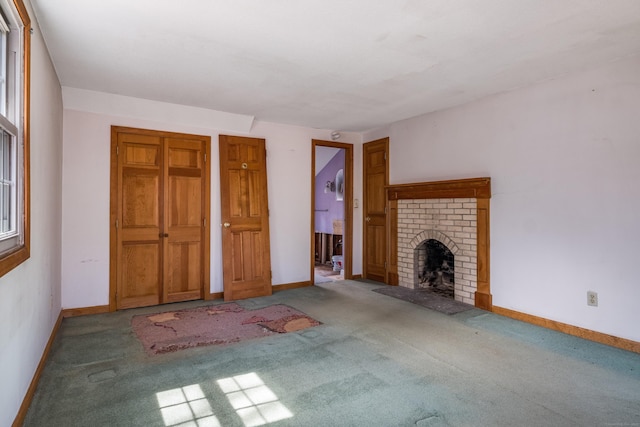 unfurnished living room featuring a fireplace, carpet flooring, and baseboards