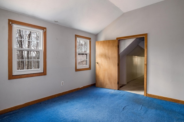 unfurnished bedroom featuring baseboards, carpet flooring, and vaulted ceiling