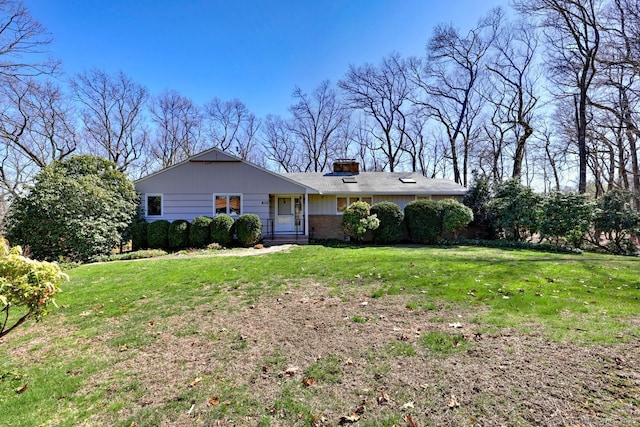 view of front of property featuring a front lawn and a chimney