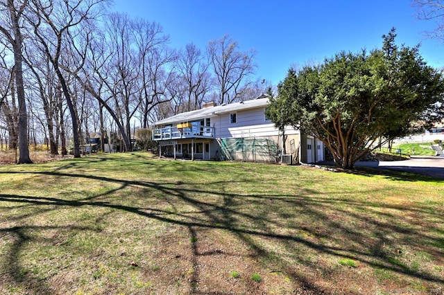 view of green lawn with a deck and stairway