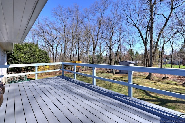 wooden terrace featuring a yard and view of wooded area