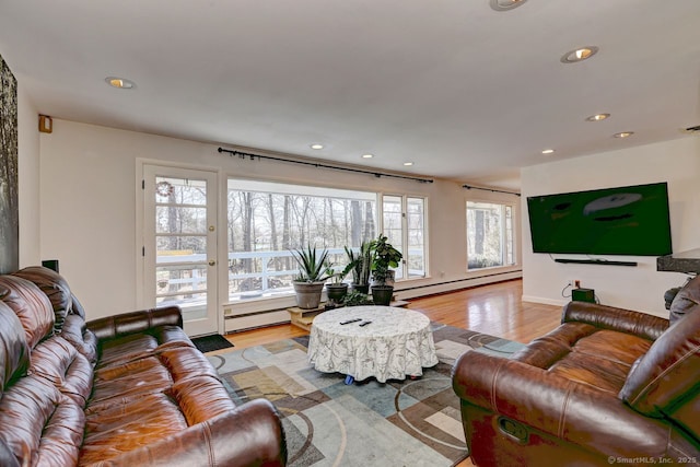 living room with a baseboard heating unit, recessed lighting, and light wood finished floors