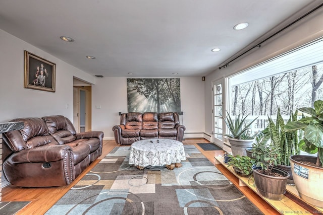 living room featuring light wood-type flooring, recessed lighting, baseboard heating, and baseboards