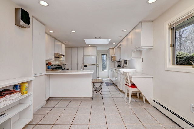 kitchen featuring a baseboard heating unit, under cabinet range hood, stainless steel electric range oven, recessed lighting, and a peninsula