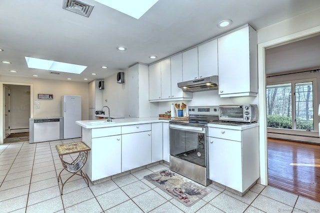 kitchen featuring under cabinet range hood, a skylight, appliances with stainless steel finishes, a peninsula, and recessed lighting