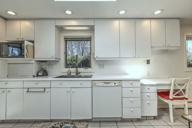kitchen featuring dishwasher, black microwave, light countertops, a sink, and recessed lighting