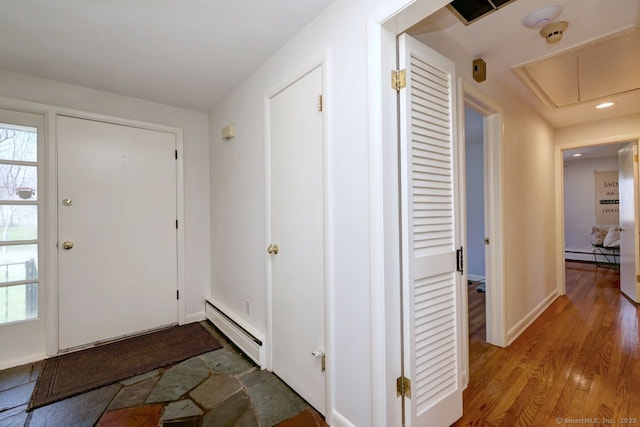 foyer featuring a baseboard heating unit, wood finished floors, and recessed lighting