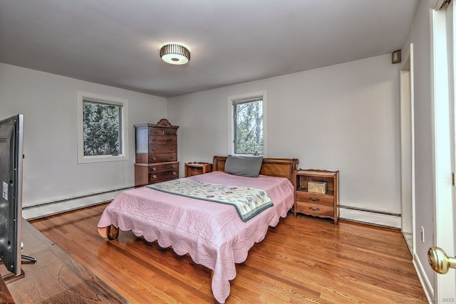 bedroom with baseboard heating and light wood-style flooring