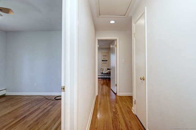 hall featuring light wood-type flooring, baseboards, recessed lighting, and a baseboard radiator