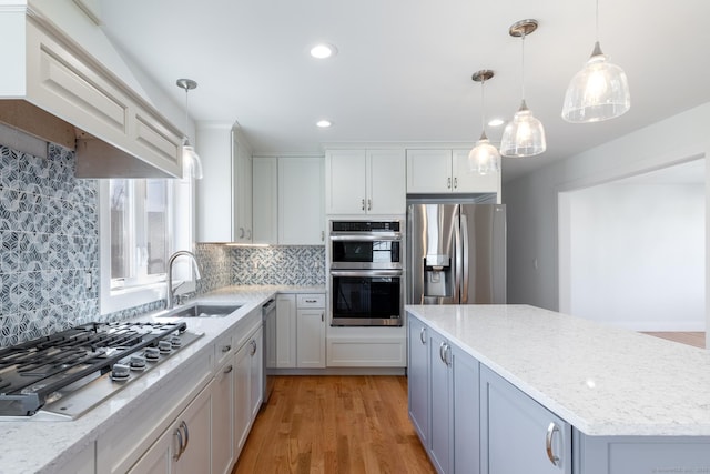 kitchen with backsplash, stainless steel appliances, a kitchen island, and a sink