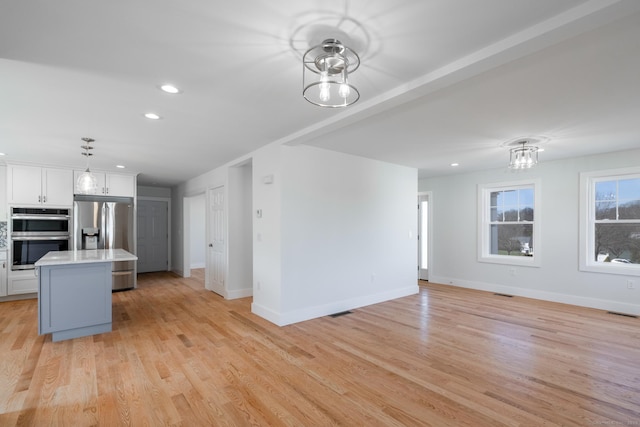 unfurnished living room with baseboards, recessed lighting, and light wood-style floors