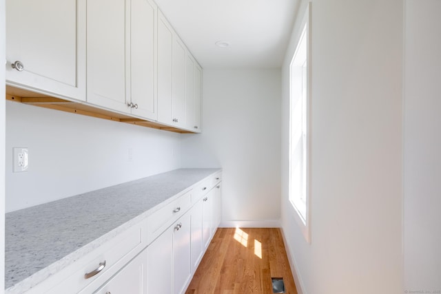bar with light wood-style flooring and baseboards