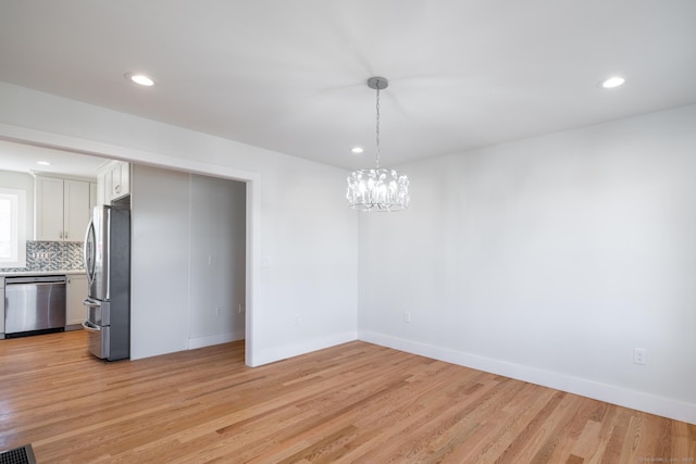 unfurnished dining area with recessed lighting, light wood-style flooring, visible vents, and a notable chandelier