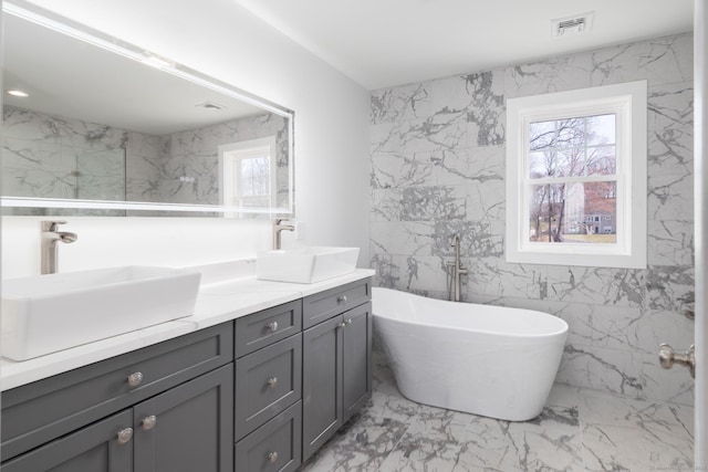 bathroom with visible vents, marble finish floor, a sink, and double vanity