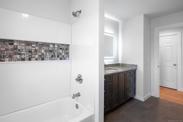 full bath with baseboards, washtub / shower combination, tile patterned flooring, and vanity