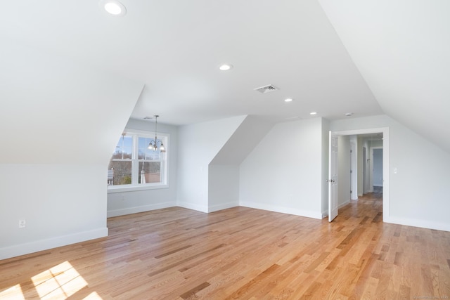 additional living space with recessed lighting, lofted ceiling, an inviting chandelier, visible vents, and light wood-style flooring