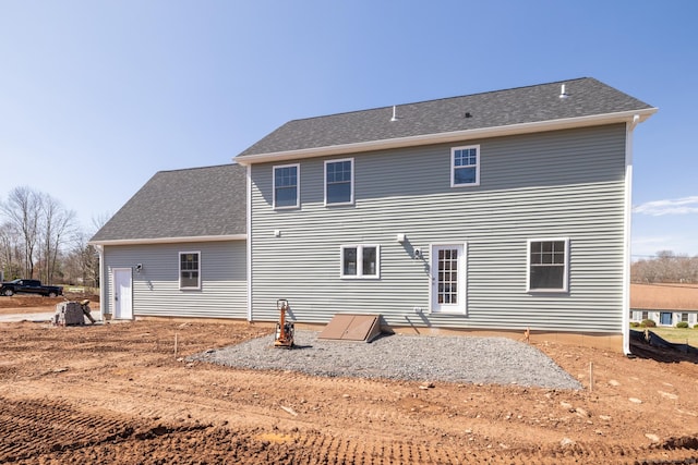 back of house with roof with shingles