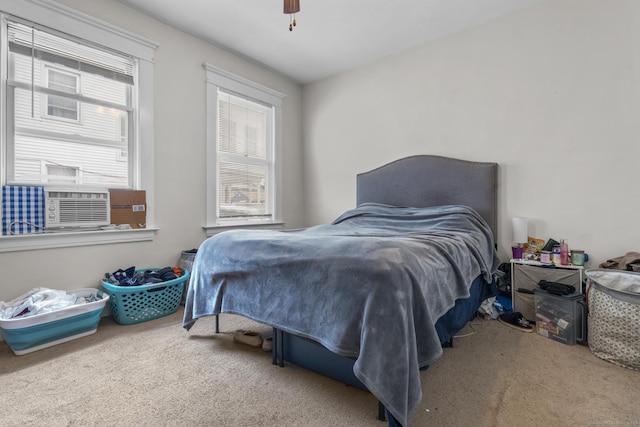 carpeted bedroom with a ceiling fan and cooling unit