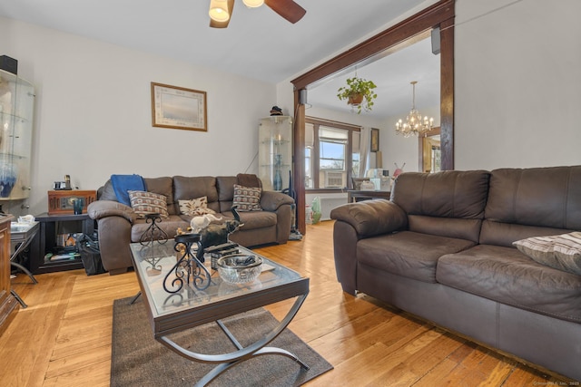 living area featuring ceiling fan with notable chandelier and light wood-style floors