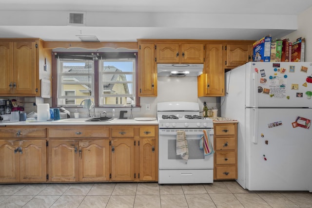 kitchen featuring visible vents, white appliances, light countertops, under cabinet range hood, and a sink