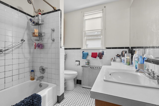 full bath with vanity, toilet, radiator heating unit, a wainscoted wall, and shower / bathing tub combination