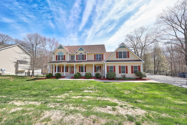 view of front of home featuring a porch, fence, and a front yard