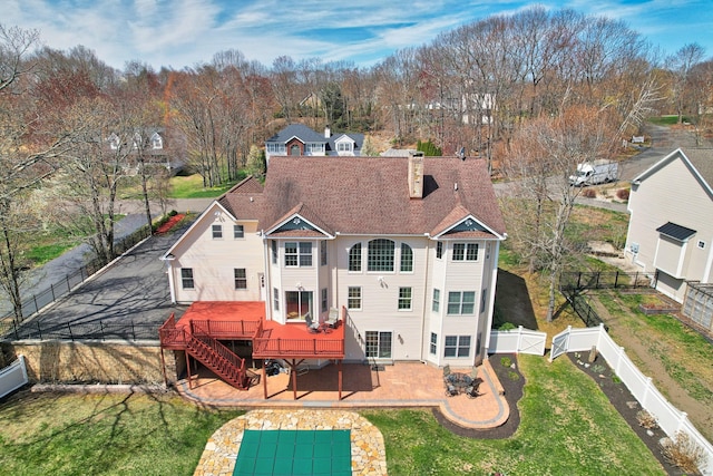 back of house featuring stairway, a fenced backyard, a wooden deck, a patio, and a lawn