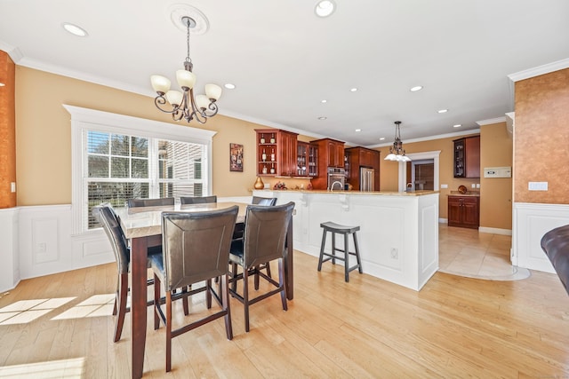 dining room with a chandelier, crown molding, and recessed lighting