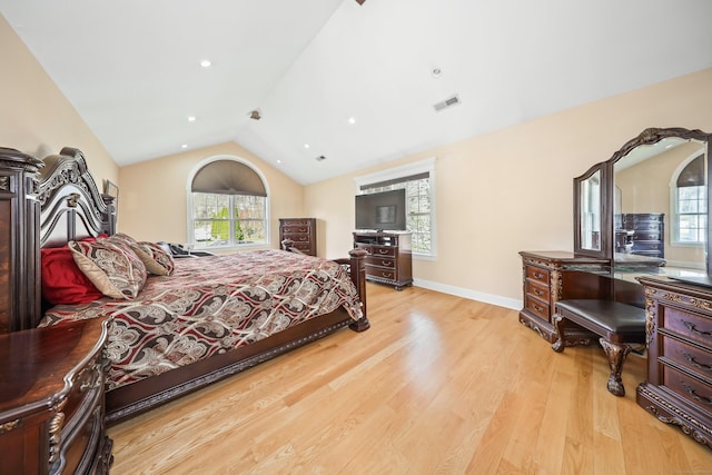 bedroom with lofted ceiling, wood finished floors, visible vents, and multiple windows