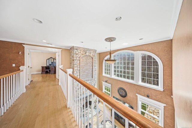hall featuring light wood finished floors, recessed lighting, an upstairs landing, and ornamental molding
