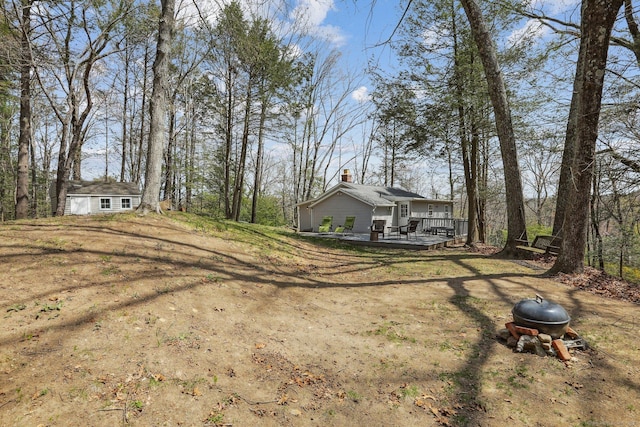 view of yard featuring an outdoor structure and a deck