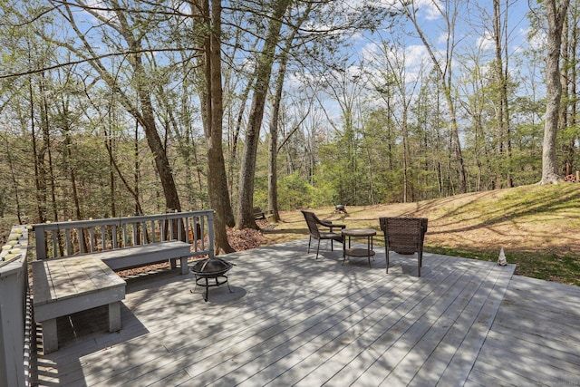 wooden deck featuring a fire pit and a wooded view