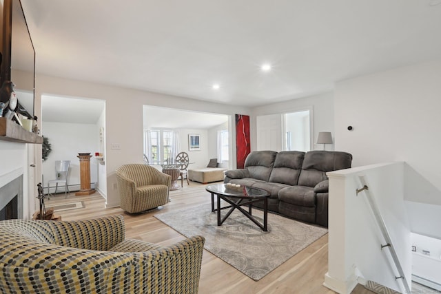 living room with recessed lighting, a fireplace, and light wood-style floors