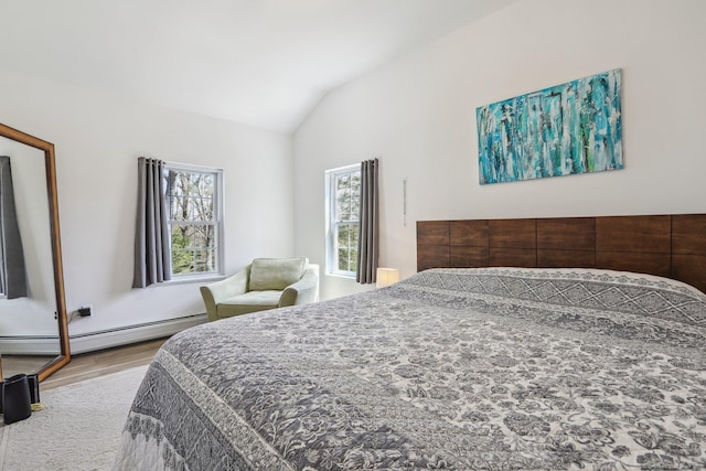 bedroom featuring a baseboard heating unit, vaulted ceiling, and wood finished floors