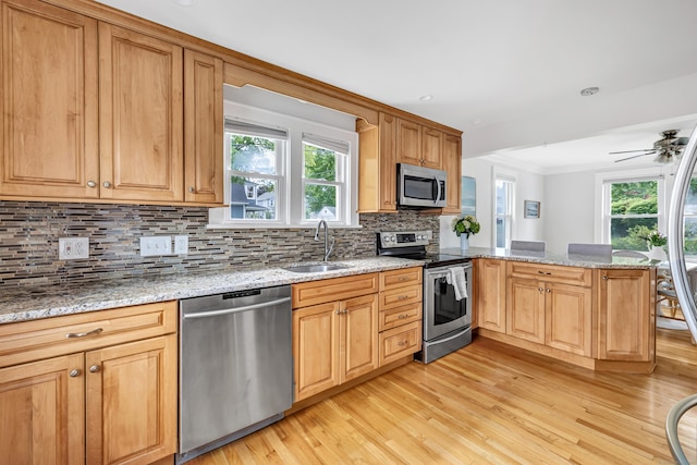435 Lenox Rd, Fairfield, CT 06825 - kitchen with stainless steel appliances, a sink, light wood finished floors, a peninsula, and backsplash