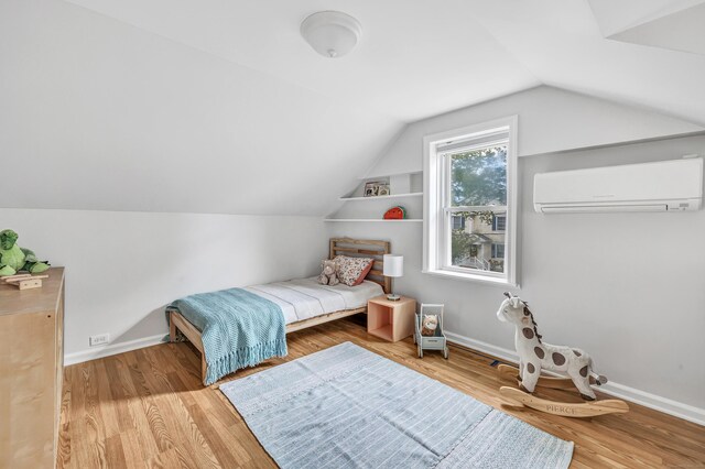 435 Lenox Rd, Fairfield, CT 06825 - bedroom with a wall unit AC, vaulted ceiling, wood finished floors, and baseboards