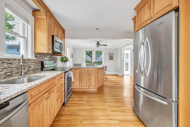435 Lenox Rd, Fairfield, CT 06825 - kitchen featuring appliances with stainless steel finishes, a sink, light wood-style flooring, a peninsula, and tasteful backsplash