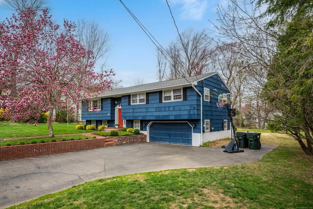 split foyer home with driveway, a front yard, and a garage