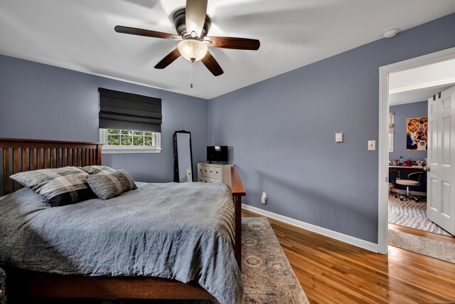 bedroom with a ceiling fan, baseboards, and wood finished floors