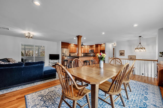 dining area with visible vents, decorative columns, recessed lighting, light wood finished floors, and a notable chandelier