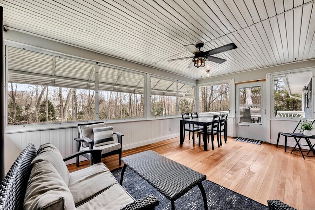 sunroom featuring outdoor lounge area, ceiling fan, wood finished floors, and a deck