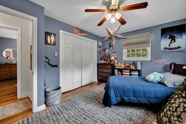 bedroom featuring baseboards, a ceiling fan, a closet, and wood finished floors