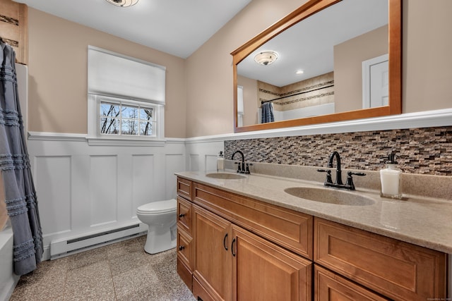 full bathroom with a sink, baseboard heating, wainscoting, and granite finish floor