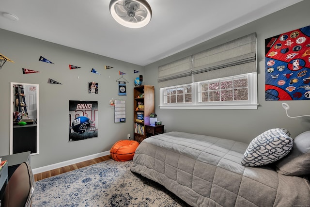 bedroom featuring baseboards and wood finished floors